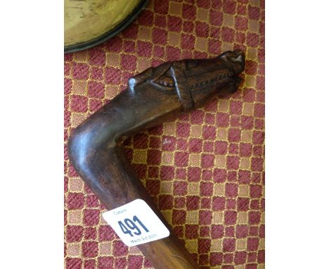 A carved wood Russian walking stick with horse head handle.