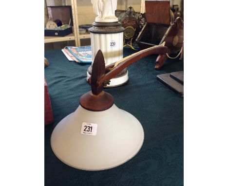 A wall mounting teak angle lamp with white glass shade.