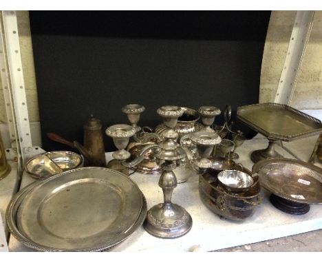 A shelf containing a large quantity of various silver plated items.