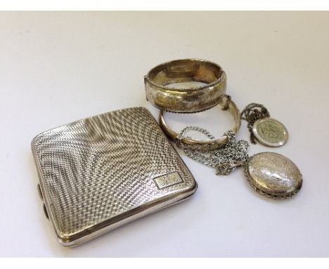 An engine turned silver cigarette case together with two silver bangles, a silver St. Christopher on chain and a silver locke