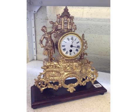 A gold painted French metal mantle clock with figural decoration.