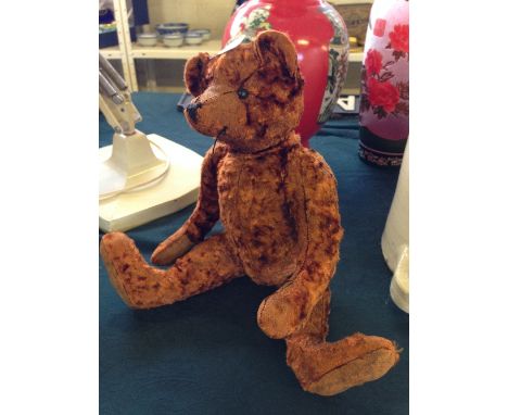 A jointed teddy bear in the style of Steiff.