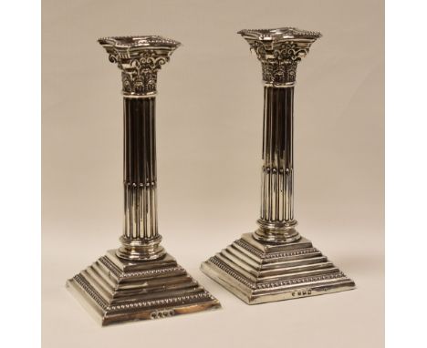 PAIR OF SILVER CORINTHIAN COLUMN CANDLESTICK-HOLDERS, on stepped square bases, Birmingham 1912, 22cms high (weighted)