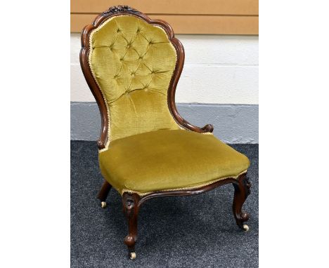 A QUEEN ANNE STYLED BUTTON-BACKED BEDROOM CHAIR with foliate carving to the top with ball and claw castor feet to the front, 