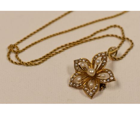 9CT YELLOW GOLD & SEED PEARL PENDANT of floral form and on a fine rope-chain necklace