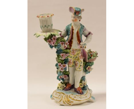 ATTRIBUTED TO DERBY PORCELAIN FIGURE OF A GARDENER standing on a scroll base with gilding decorated in bright gaudy colours a