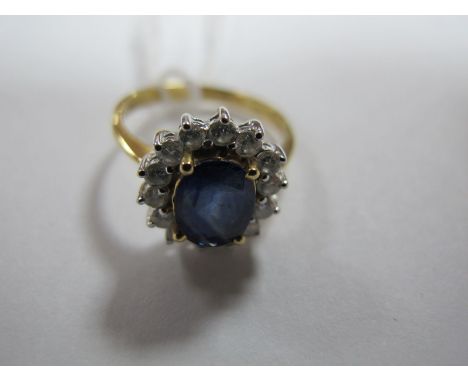 A Modern Sapphire and Diamond Cluster Ring, oval four claw set to the centre, within claw set border of brilliant cut diamond
