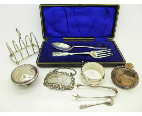 Assorted silver items;- a brandy label, toast rack, napkin ring, sugar bows, salt spoon, bottle top and christening spoon and