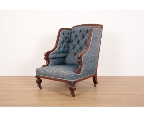 A MAHOGANY WINGBACK ARMCHAIR19th century, with button back floral pattern covers, the carved cresting rail over scrolling arm