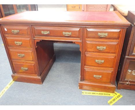 A LATE VICTORIAN WALNUT DESK with red leather surface, and brass handles 122 cm wide