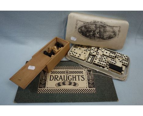 A 19TH CENTURY SET OF DOMINOES in bone and ivory, in a silk covered box, a collection of small wooden chess pieces and a drau