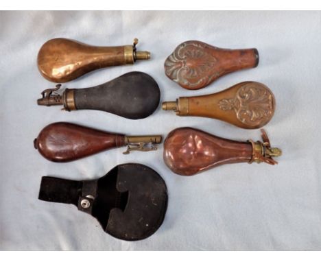 A LEATHER COVERED POWDER FLASK, other copper examples, and a leather holder