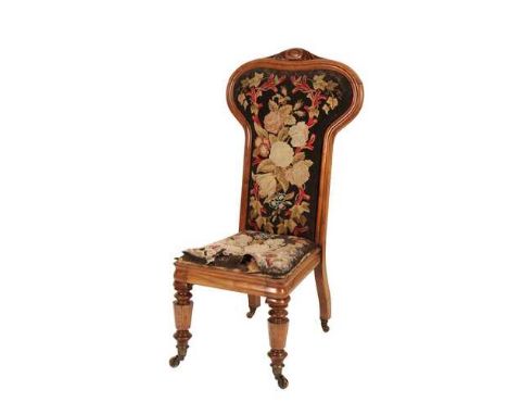 A VICTORIAN WALNUT AND TAPESTRY UPHOLSTERED PRIE DIEU CHAIR IN REFORMED GOTHIC STYLE Circa 1870, the backrest with carved sha