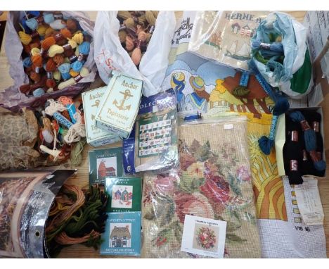 A COLLECTION OF PARTIALLY MADE AND UNMADE NEEDLEPOINT/TAPESTRY KITS AND WOOLS