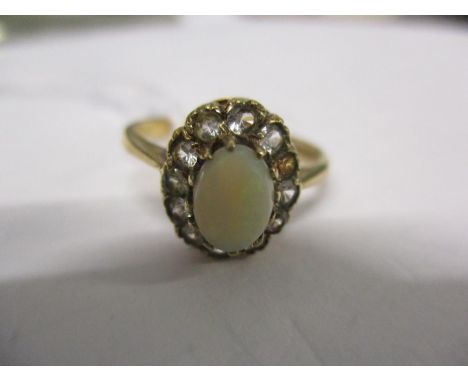 A 9ct gold, opal and diamond ring having a central opal surrounded by eleven small diamonds (one is missing). Total weight 2.