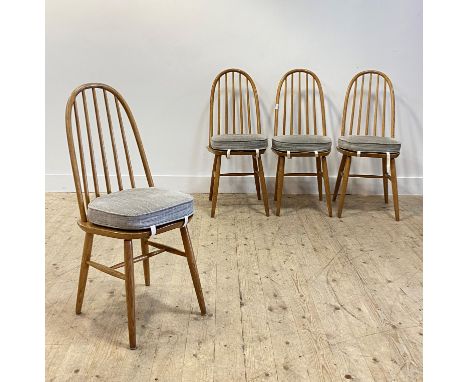 A set of four mid century oak dining chairs by Priory, in the Ercol style, hoop and spindle back over shaped seat with squab 