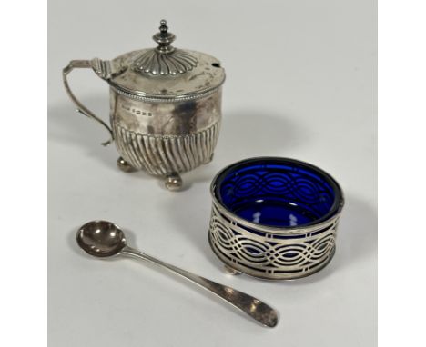 A Victorian Birmingham silver half spiral lobed drum mustard with urn finial raised on four ball feet, with later blue glass 