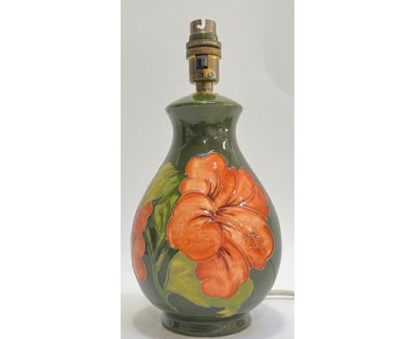 A Moorcroft pottery 'Hibiscus' lamp decorated with red tube lined flowers on a green ground (marked verso) (height including 