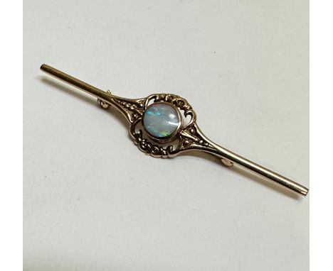 A 9ct gold bar brooch set circular water opal in rub over setting enclosed within a open scroll border, approximately 1ct. (l