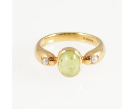 A peridot and pearl dress ring, an oval cabochon cut peridot collet set with a seed pearl to each side in an 18 carat all yel