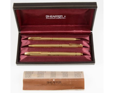 A Sheaffer 18 carat yellow gold three piece pen set comprising a fountain pen, ballpoint pen and propelling pencil, engine tu