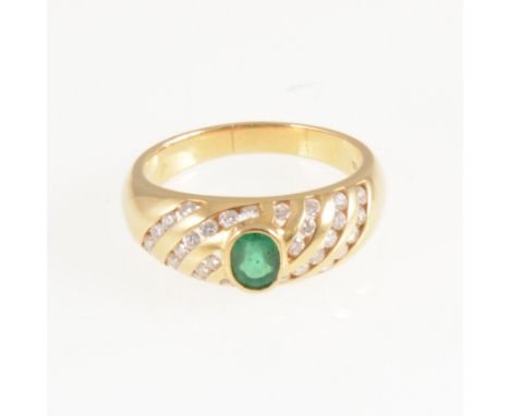 An emerald and diamond dress ring, the oval mixed cut emerald collet set in an all yellow metal domed shape mount marked 750 