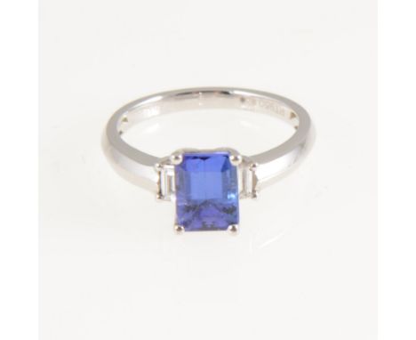 A tanzanite and diamond ring, the square cut tanzanite 7.9mm x 6mm, four claw set in a platinum mount with a baguette cut dia