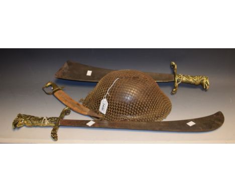 A WWII Brodie helmet with scrim netting; wall hanging sword with ornate brass hilt and crossguard; others similar (4)
