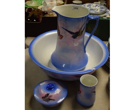 An Edwardian toilet set comprising basin, jug, jar and soap dish with insert, sky blue and pink ground, printed British garde