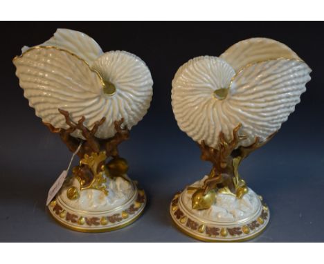 A pair Royal Worcester nautilus shell vases, the shell supported on coral, highlighted in brown and gilt, 20.5cm high, puce d