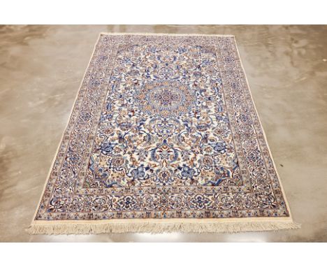 A NAIN WOOL AND SILK CARPET (300 x 200cm) Hand knotted wool with 30% silk, floral medallion design on an ivory ground Conditi