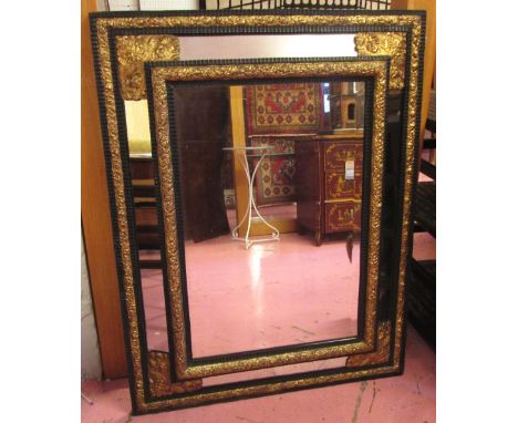 WALL MIRROR, 19th century Flemish with gilt repousse metal work and ebonised detail and a bevelled main plate, 110cm W x 87cm