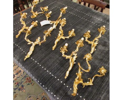 WALL LIGHTS, a set of four, Louis XV style, gilt metal with twin lighting arms, 40cm H, plus two similar pairs. (8)