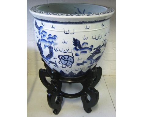 CHINESE CARP BOWL, 20th century blue/white ceramic decorated carp and dragons, 38cm diam x 33cm H plus ebonised stand. (2)