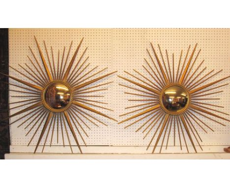 STARBURST MIRRORS, a pair, mid 20th century gilt metal each with convex mirror plate, 86cm W. (2)