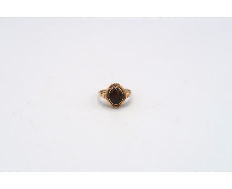 A tigers eye oval panel ring. Size O 1/2. Stamped 14K. Weight approx 3.28 grams. 