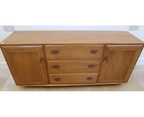 An Ercol mid 20th Century blonde elm sideboard, three central drawers flanked by doors, top drawer with sliding flatware tray