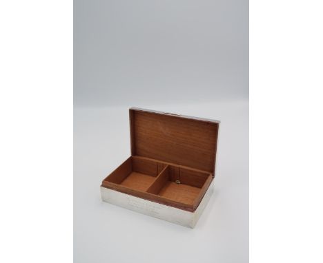 A silver hallmarked cigarette box, London 1935, with engine turned decoration 