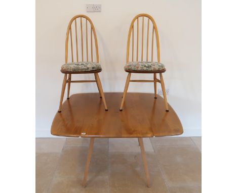 An Ercol blonde elm drop leaf dining table raised on tapering legs with two chairs - 112cm x 123cm x 73cm high. 