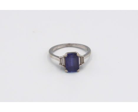 An 18ct white gold tanzanite and diamond ring, the central tanzanite flanked by four baguette cut diamonds, size L, approx 3.