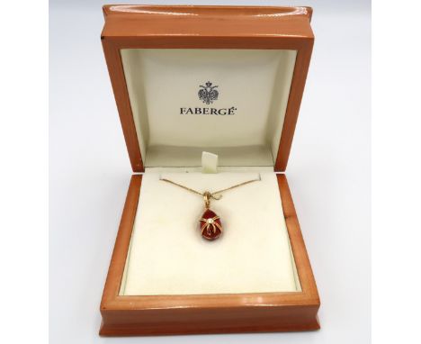 A Faberge egg pendant decorated in 18ct yellow gold with red enamel, diamond to centre of bow with suspension loop above on a