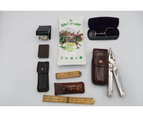 A wooden desk diary, a set of folding bookshelves, a large wooden gavel, a wall barometer, a ceramic pin tray Le Tierce Gagna