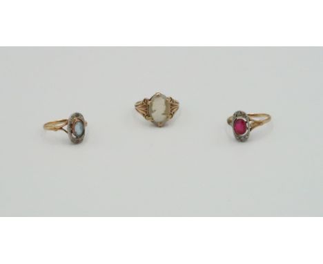 Three rings to include an oval ruby and diamond panel ring, size N, weight approx 2.07 grams. An oval blue gem believed to be