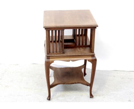 An Edwardian walnut bibliotheque tournavis supported on swept cabriole legs united by a shelf stretcher, height 76cm.