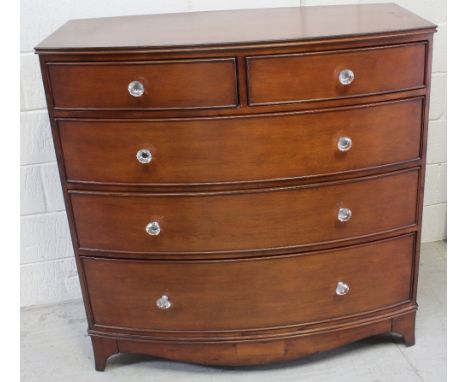 A Laura Ashley style reproduction Georgian bow-front chest of two-over-three drawers with glass handles, supported on shaped 