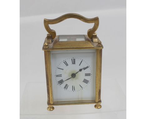A small brass French carriage clock with white enamelled rim and dial, height 9.5cm.