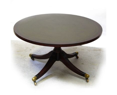 A 20th century mahogany reproduction tilt-top table on quadripartite pedestal base to brass slipper castors, height 50cm.