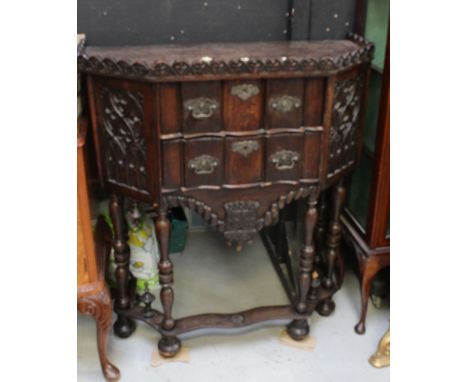 An 18th century and later Gothic oak cabinet, the earlier oak panels flank two serpentine drawers with lower apron on William