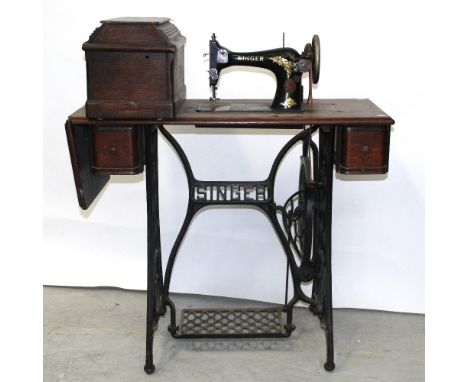 An early 20th century Singer treadle sewing machine, oak-cased, on cast iron base, model number F2651261.