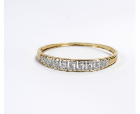 A 9ct white and yellow gold bangle pave set with small diamonds in the Greek Key pattern, approx 11g.